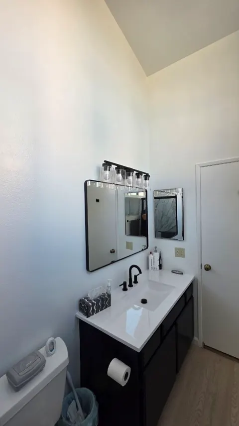 Newly installed black bathroom vanity with white top and matte black faucet