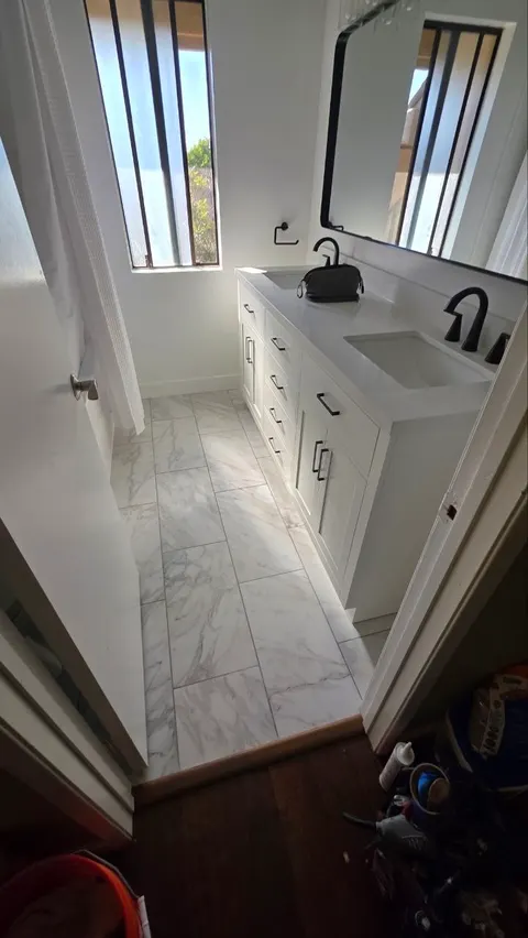 After: double vanity with white cabinets, quartz top and matte black faucets in Camarillo