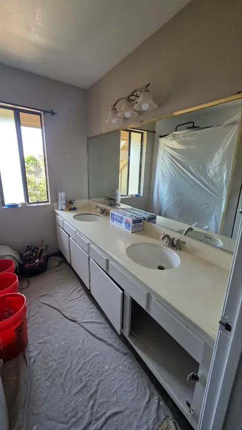 Before: old double vanity with yellowed top and dated light fixture