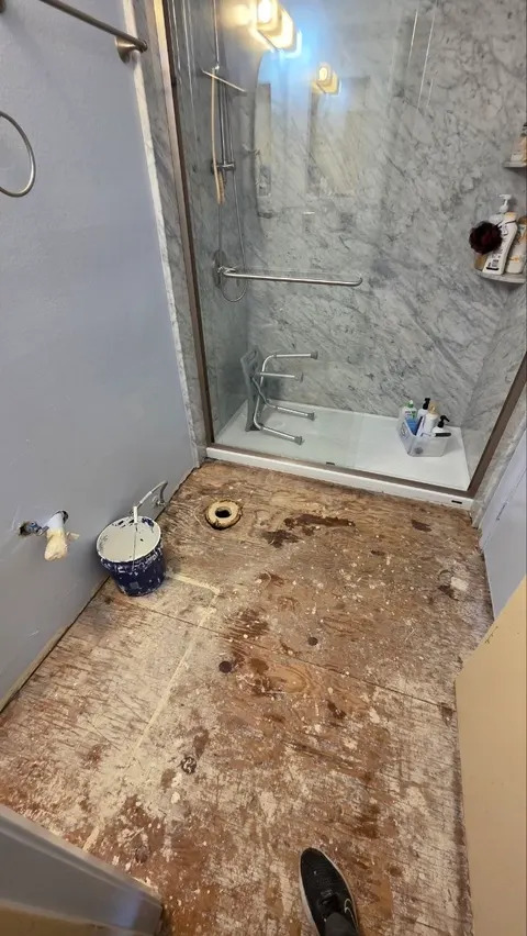 Before: bathroom floor stripped to the subfloor with the toilet removed