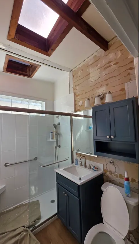 Same bathroom during the job, with the damaged wall stripped back to the paper